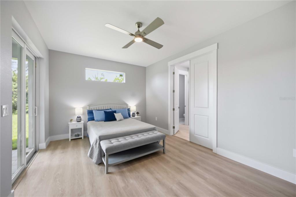 10443 Riverside Road Port Charlotte, FL 33981 - Photo 17 of 64 a bedroom with a bed and a ceiling fan