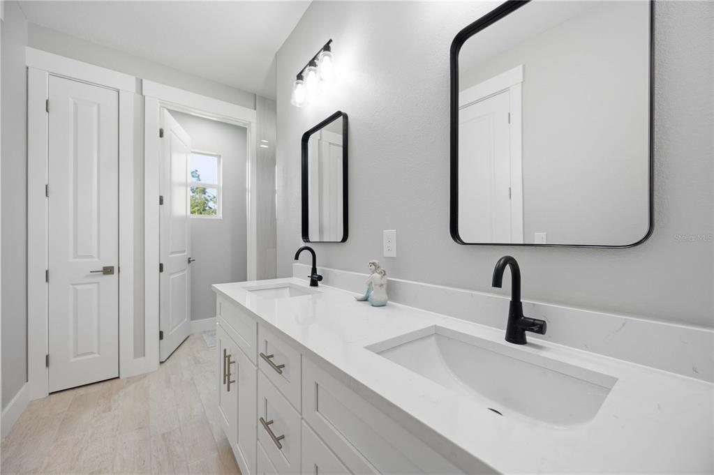10443 Riverside Road Port Charlotte, FL 33981 - Photo 23 of 64 a bathroom with double vanity sinks and a mirror