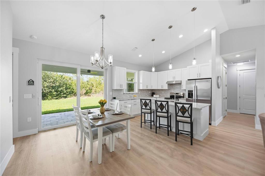 10443 Riverside Road Port Charlotte, FL 33981 - Photo 8 of 64 a view of a dining room and livingroom with furniture wooden floor a chandelier