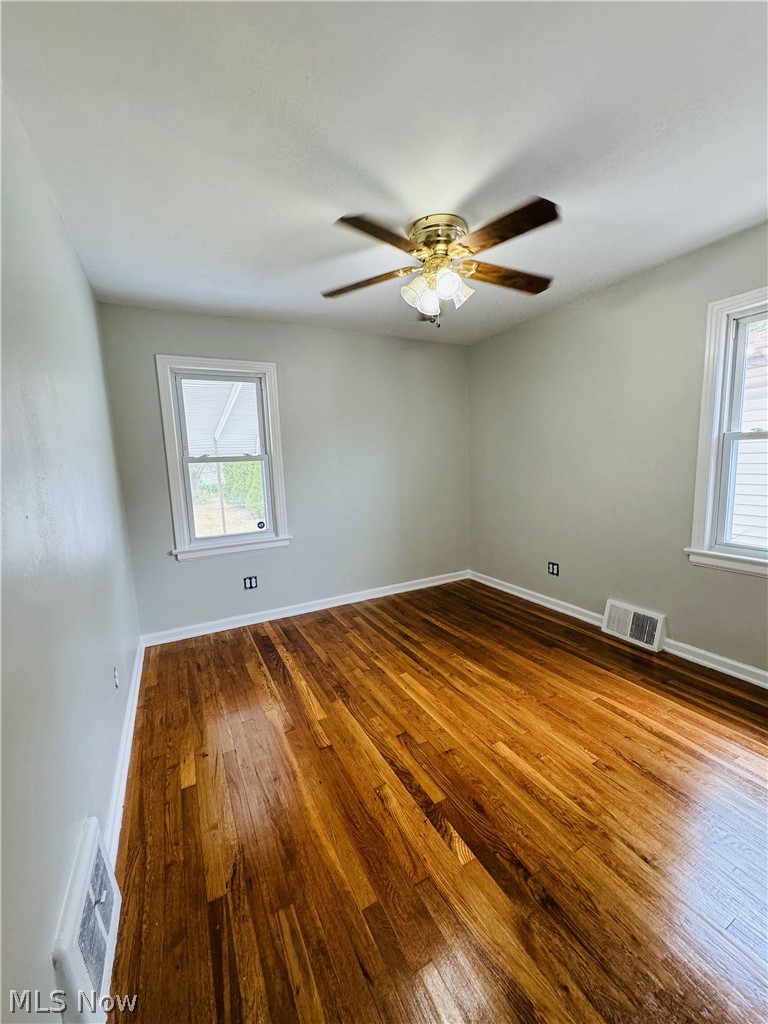 13660 Granger Road Cleveland, OH 44125 - Photo 11 of 17 Spare room featuring ceiling fan, hardwood / wood-style flooring, and a healthy amount of sunlight