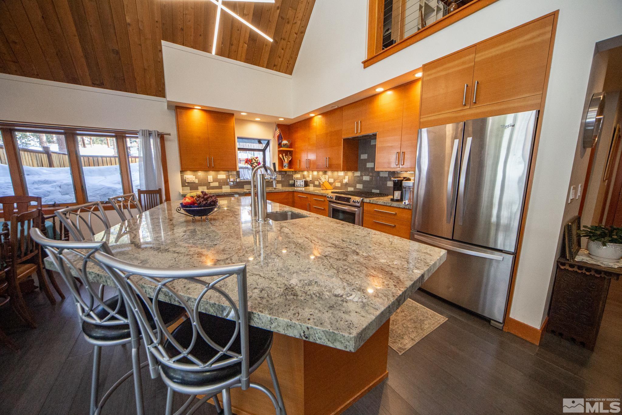 301 Cedar Drive Stateline, NV 89449 - Photo 8 of 27 a kitchen with stainless steel appliances granite countertop table chairs and a refrigerator