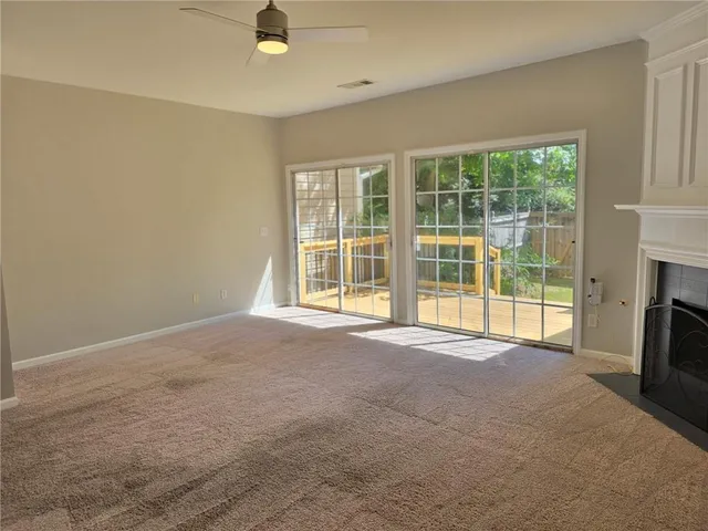 a view of an empty room with a fireplace and a window