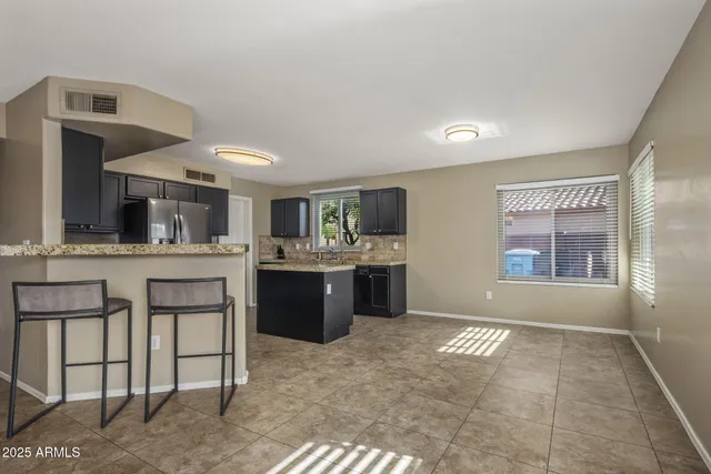 a kitchen with granite countertop stainless steel appliances a sink stove refrigerator and cabinets