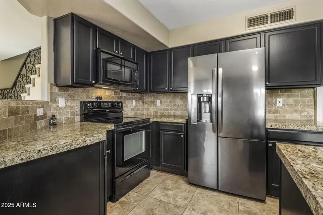 a kitchen with granite countertop a sink stove and cabinets