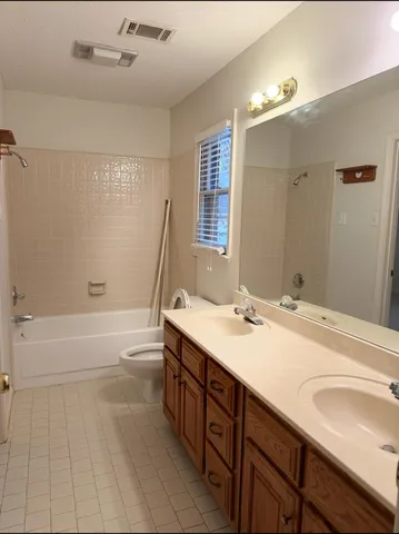 a bathroom with a sink double vanity granite tub shower and a mirror