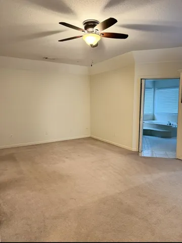 a view of a room with a ceiling fan and window