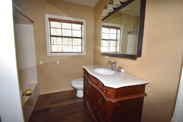 a bathroom with a sink a toilet and a window