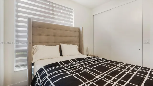 a bedroom with a bed and a window