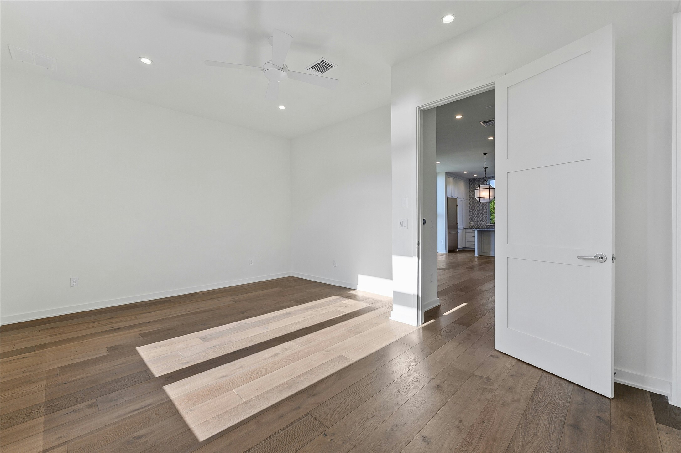 2518 Sutherland Street Austin, TX 78746 - Photo 15 of 30 Hardwood floors and bright recessed lighting create an inviting and well-lit interior.