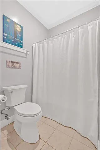 a white toilet sitting next to a shower curtain