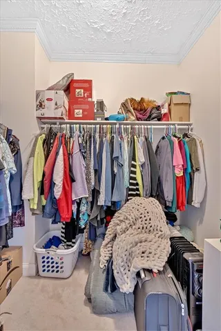a view of walk in closet with clothes and shoes
