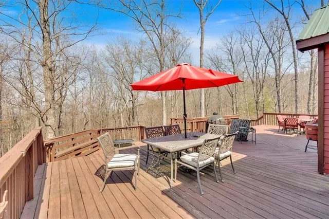 a view of deck with table and chairs under an umbrella with wooden floor