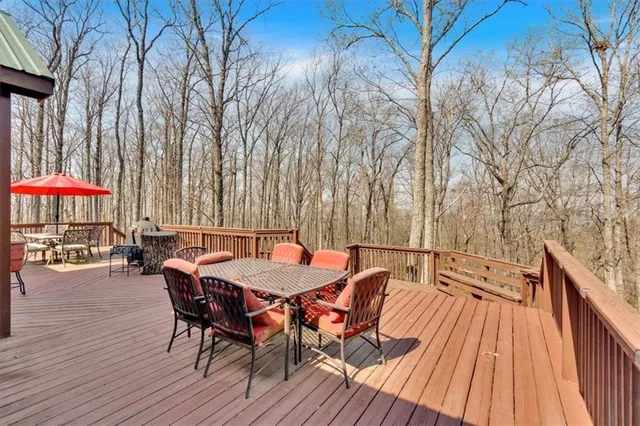 a view of a roof deck with table and chairs wooden floor and fence