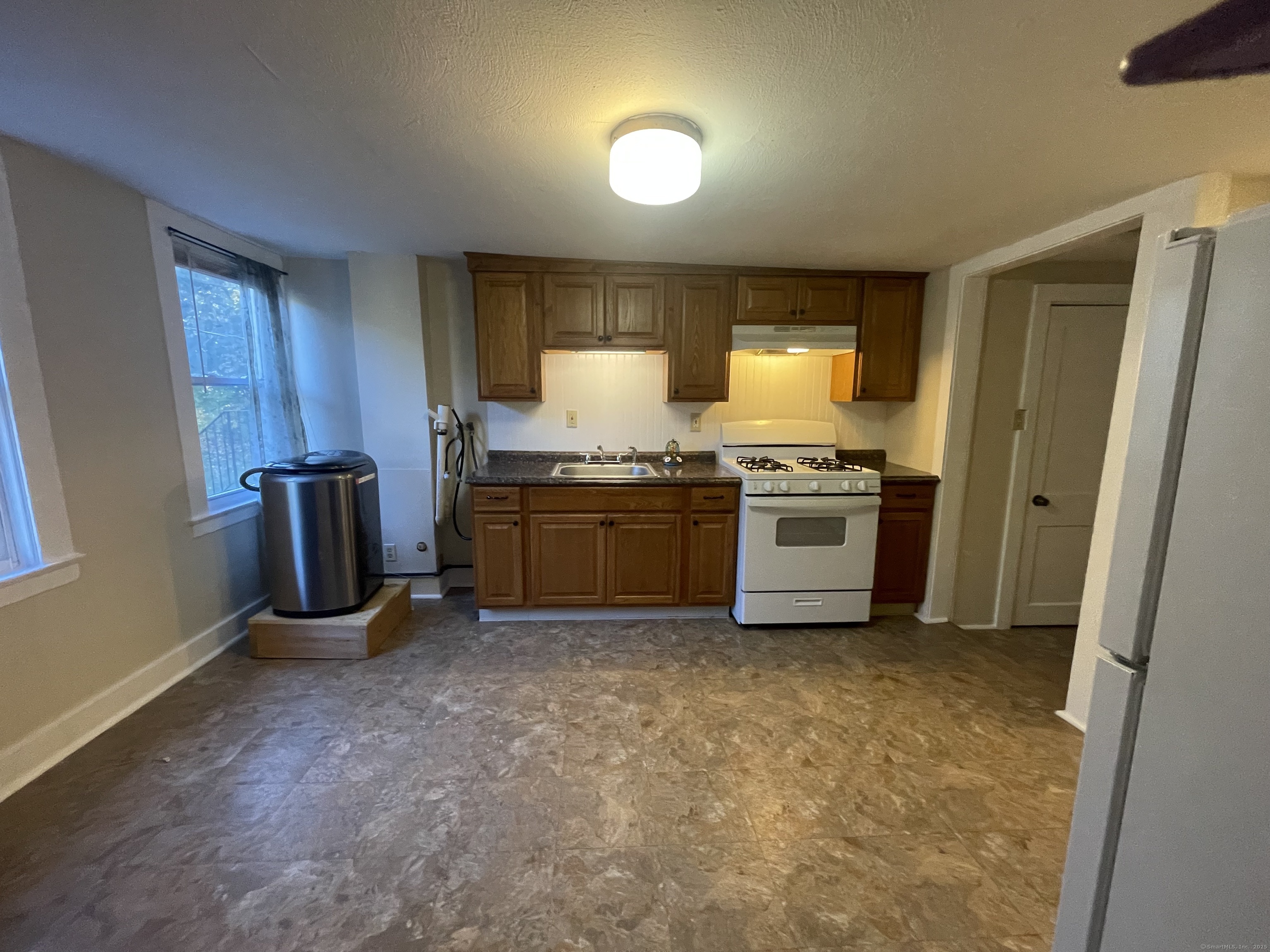 a kitchen with stainless steel appliances granite countertop a stove a sink and a refrigerator