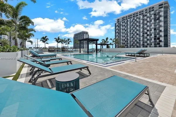 a swimming pool with a yard and outdoor seating