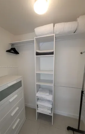 a view of walk in closet with empty racks