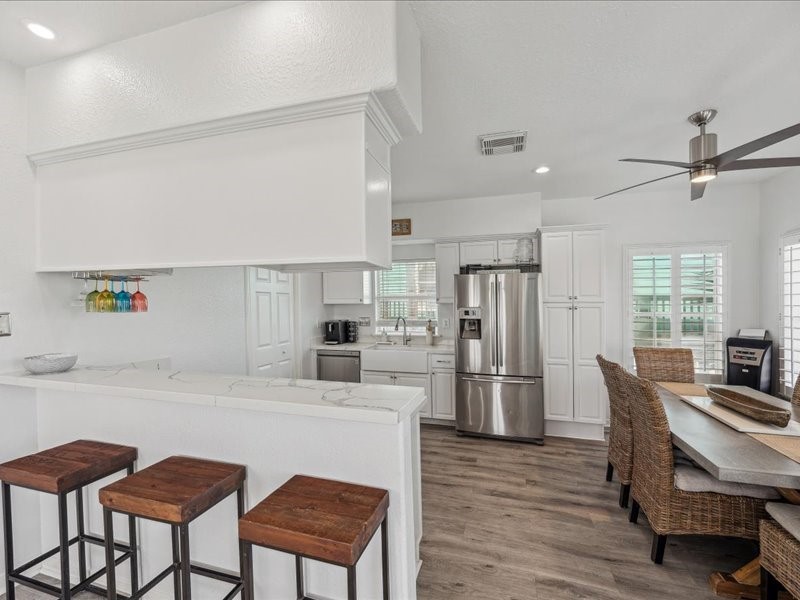 530 Dolphin Street Freeport, TX 77541 - Photo 12 of 29 a kitchen with refrigerator cabinets and dining table