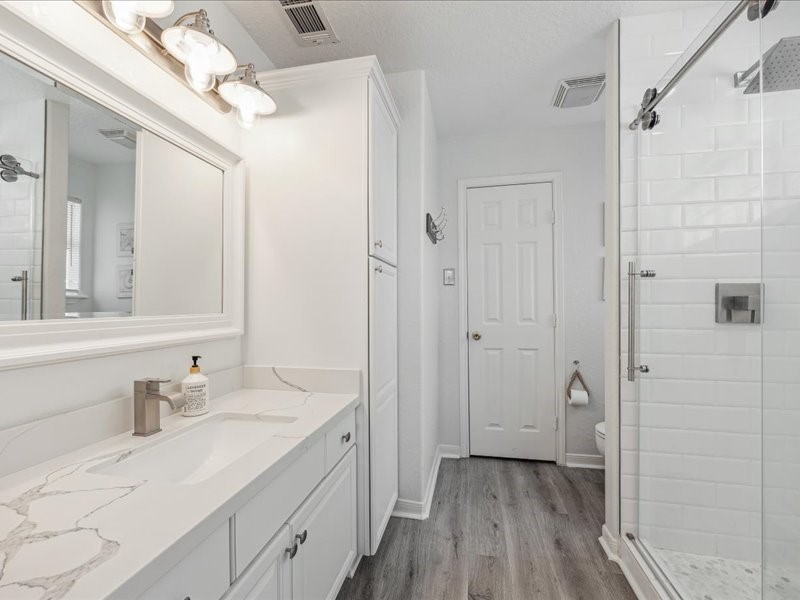 530 Dolphin Street Freeport, TX 77541 - Photo 15 of 29 a bathroom with a granite countertop sink a mirror and a shower