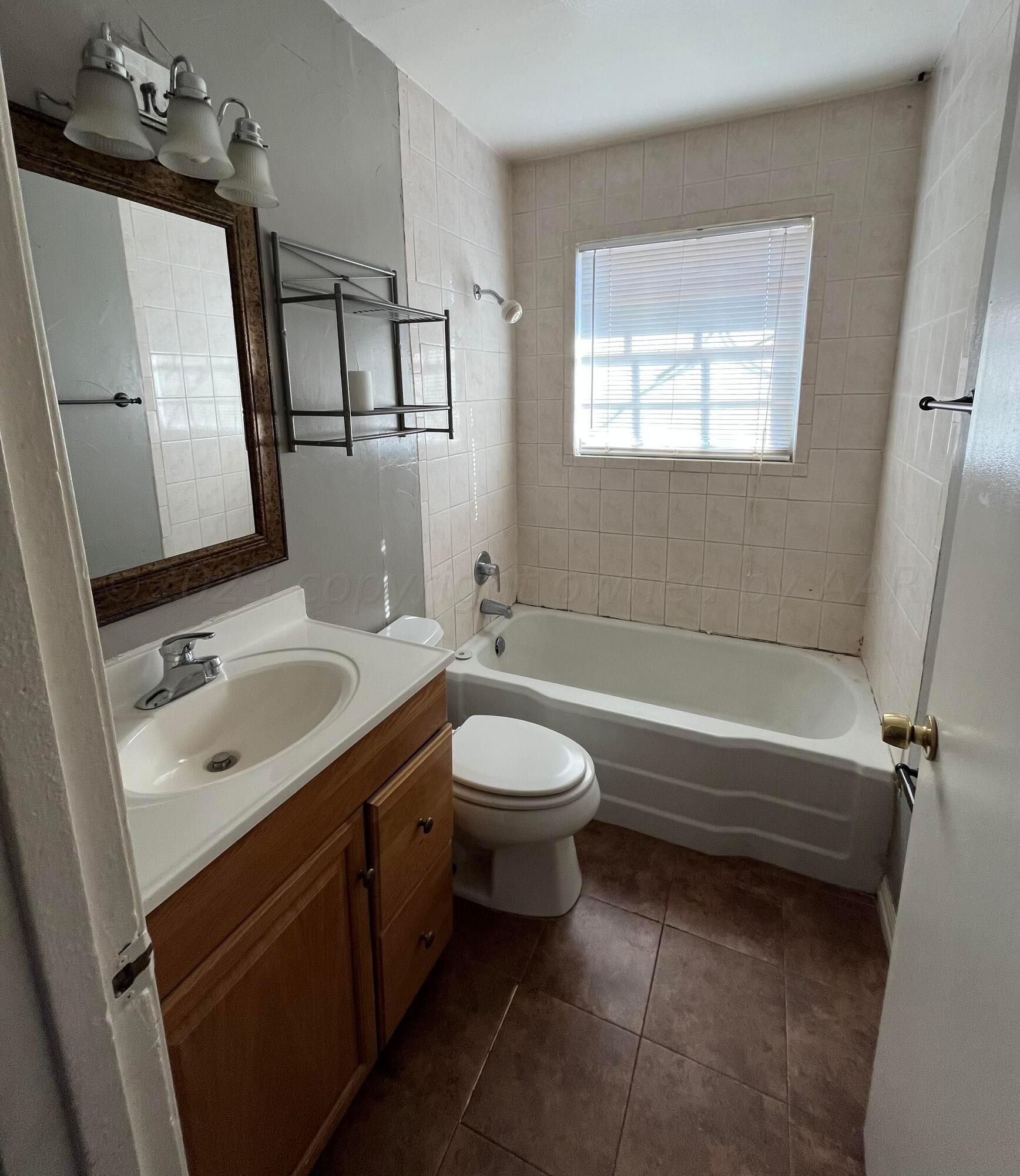 4017 Gables Street Amarillo, TX 79110 - Photo 12 of 13 a bathroom with a sink toilet and shower