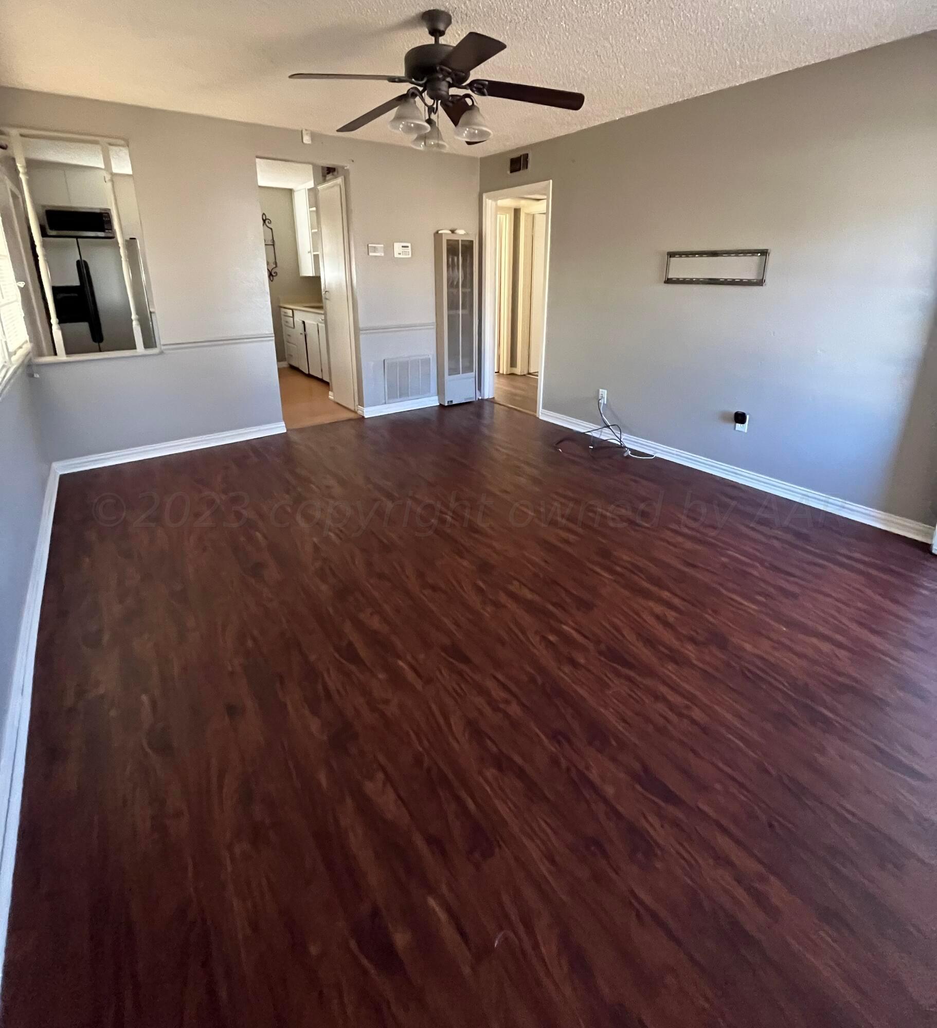 4017 Gables Street Amarillo, TX 79110 - Photo 5 of 13 wooden floor in an empty room with a window