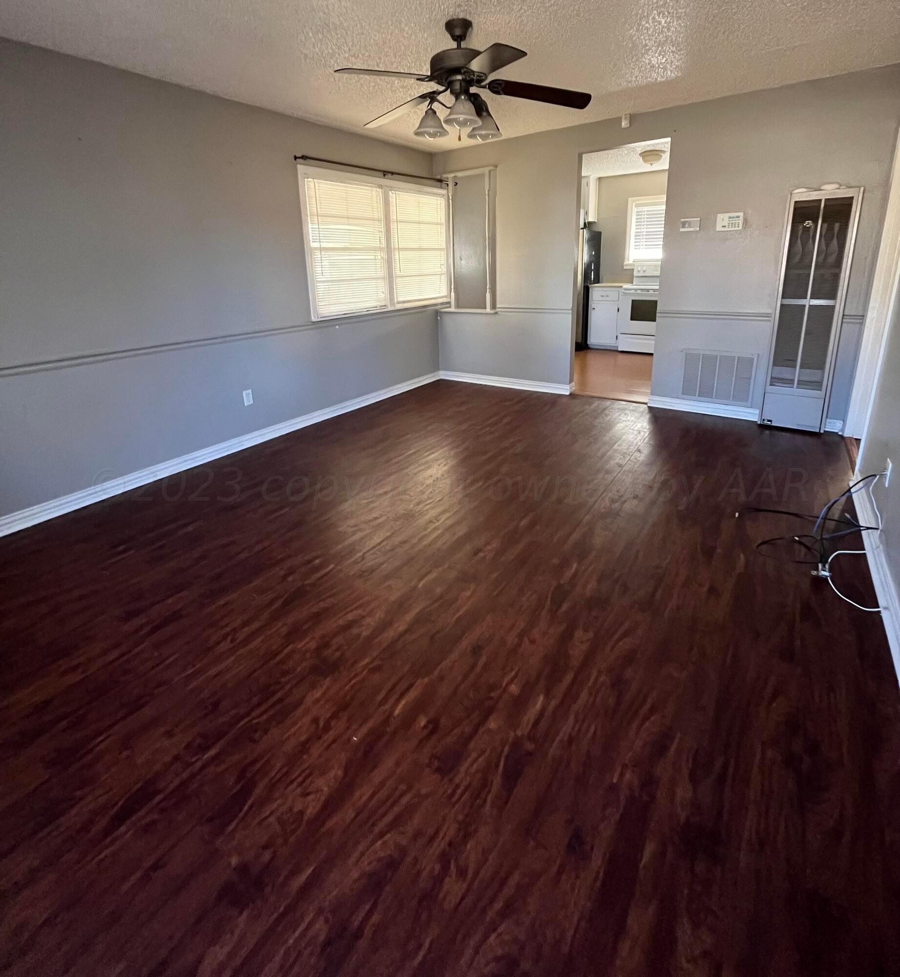 4017 Gables Street Amarillo, TX 79110 - Photo 6 of 13 wooden floor in an empty room with a window