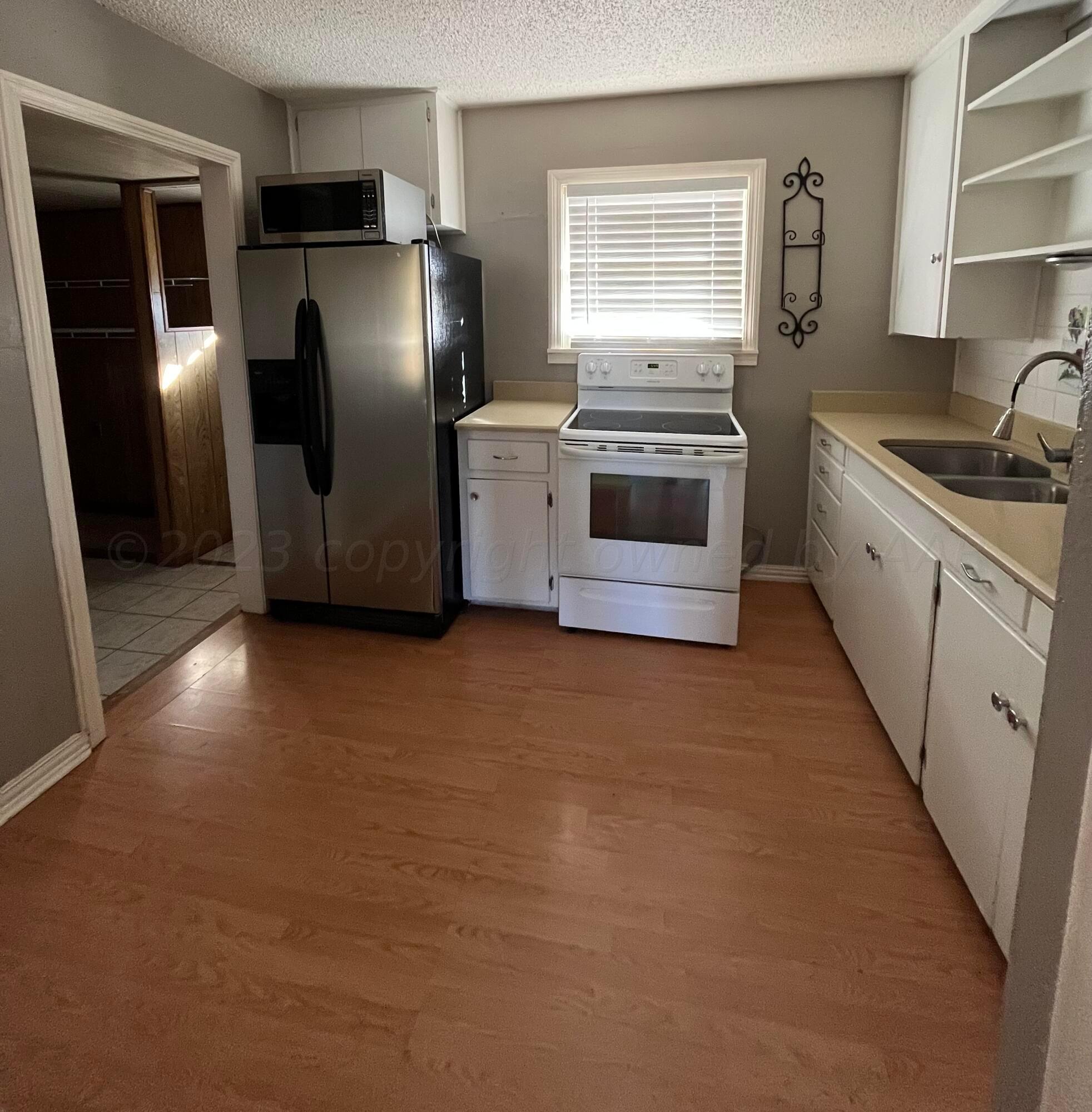 4017 Gables Street Amarillo, TX 79110 - Photo 7 of 13 a kitchen with stainless steel appliances a refrigerator sink and stove