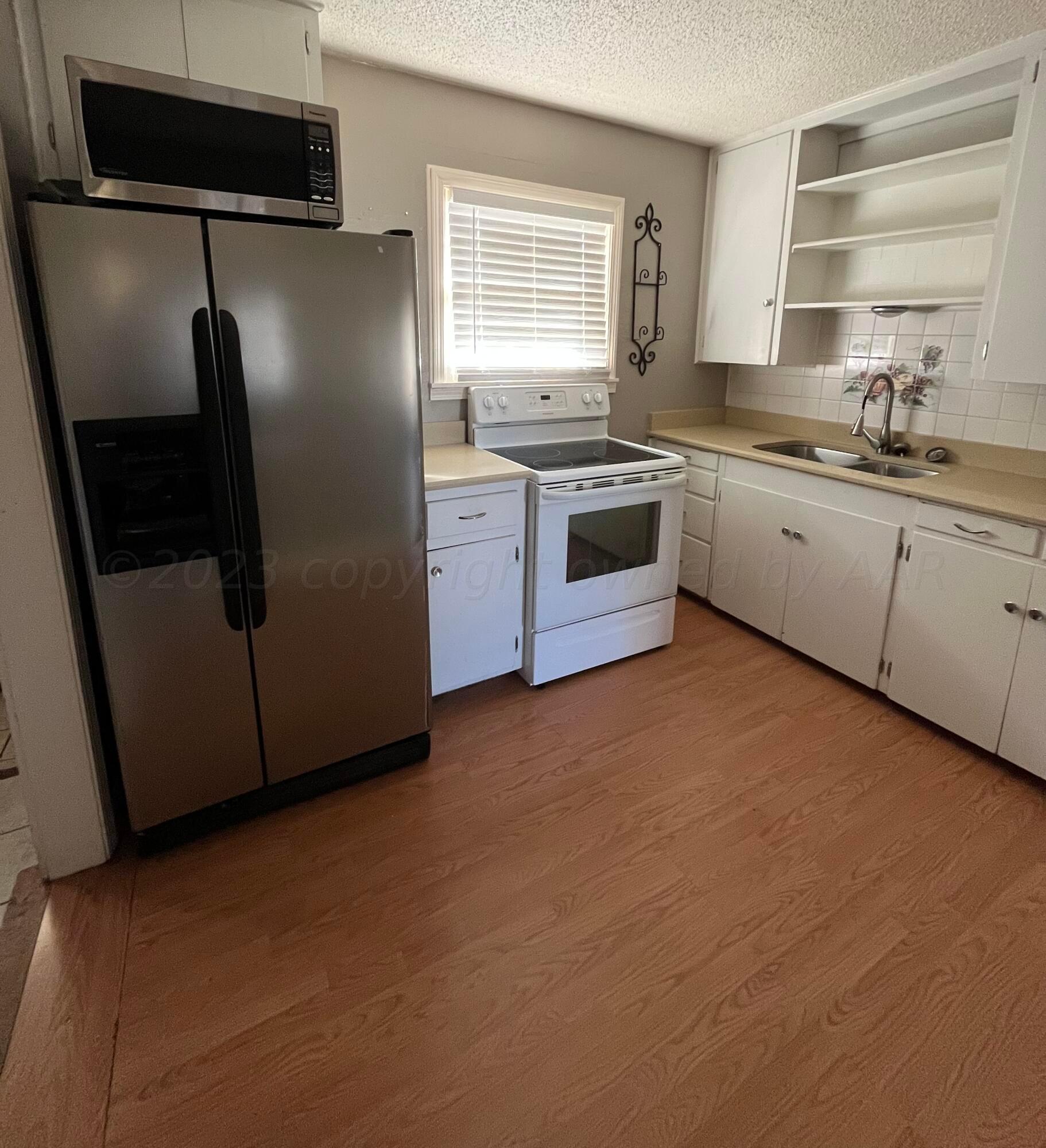 4017 Gables Street Amarillo, TX 79110 - Photo 8 of 13 a kitchen with stainless steel appliances a refrigerator sink and cabinets