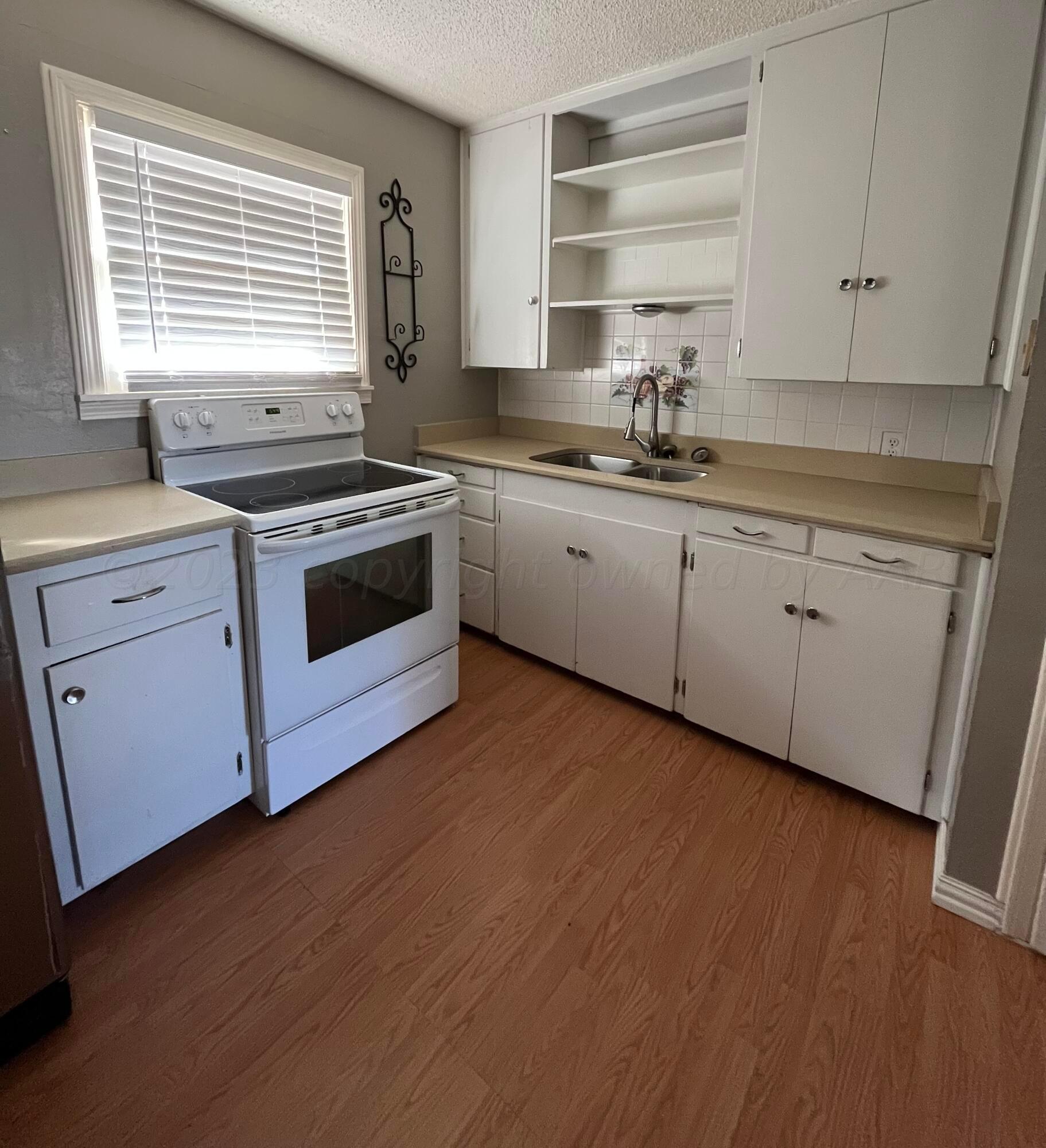 4017 Gables Street Amarillo, TX 79110 - Photo 9 of 13 a kitchen with granite countertop white cabinets and white appliances