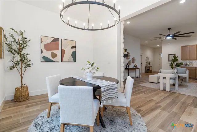 a kitchen with a table chairs sink and cabinets