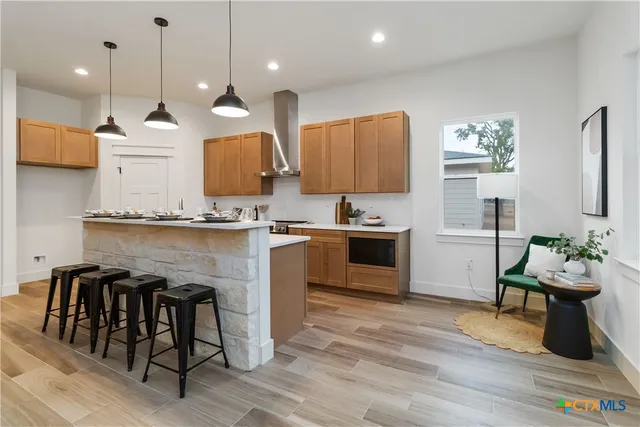 a kitchen with stainless steel appliances granite countertop a sink a stove and a wooden floors