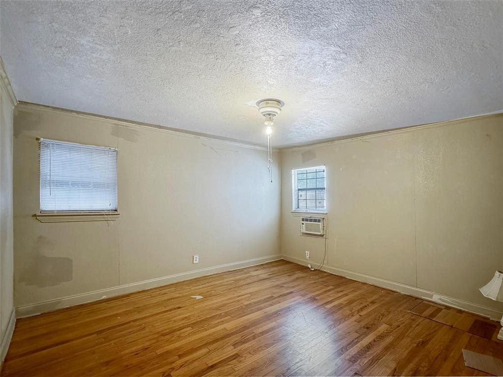 5532 Junius Street Dallas, TX 75214 - Photo 5 of 9 a view of an empty room with wooden floor and a window
