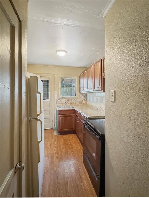 5532 Junius Street Dallas, TX 75214 - Photo 6 of 9 a kitchen with stainless steel appliances granite countertop a refrigerator a sink dishwasher a stove with wooden floor and cabinets