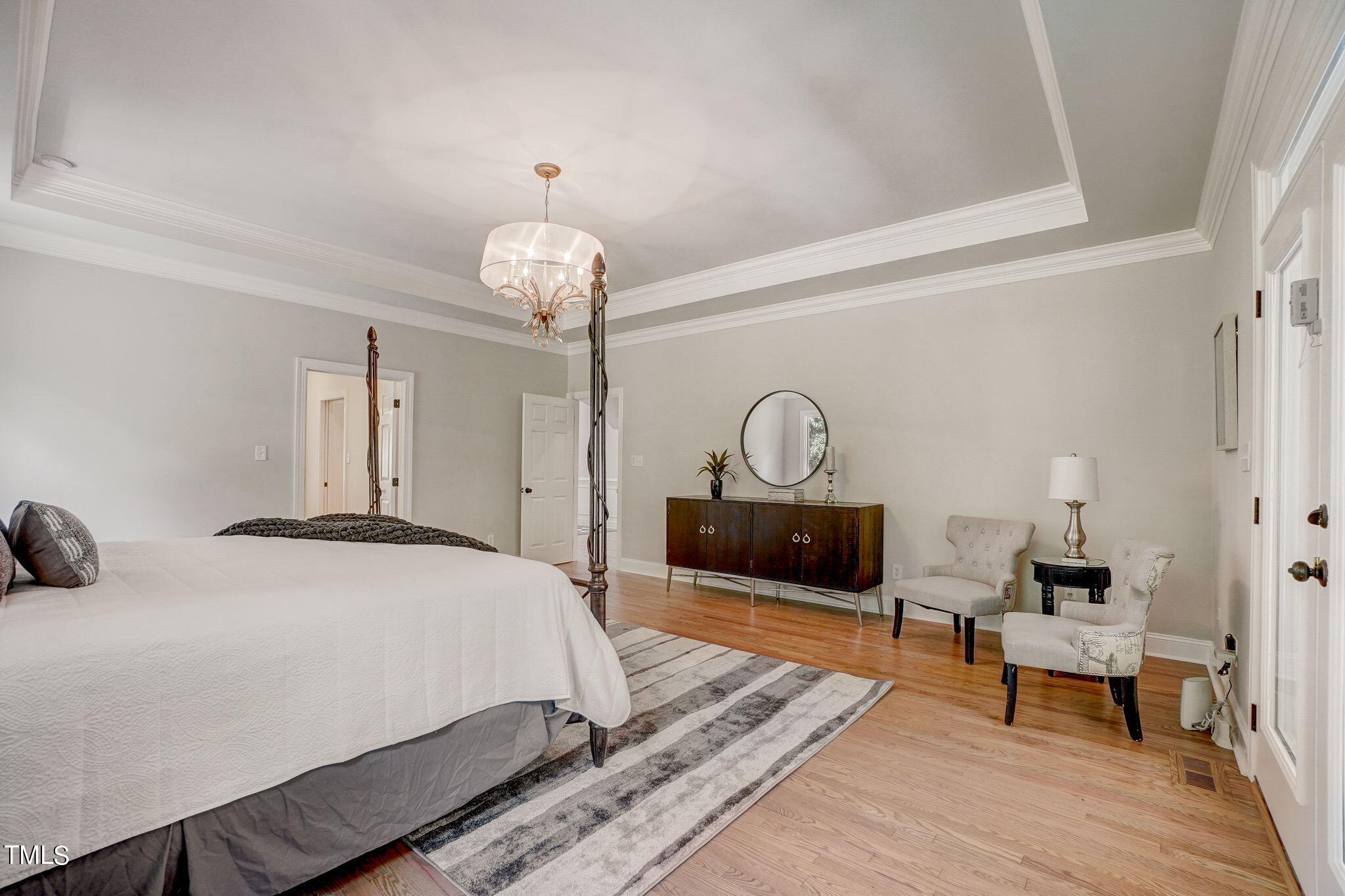 5101 Roseland Court Raleigh, NC 27613 - Photo 23 of 71 a bedroom with a bed and a chandelier