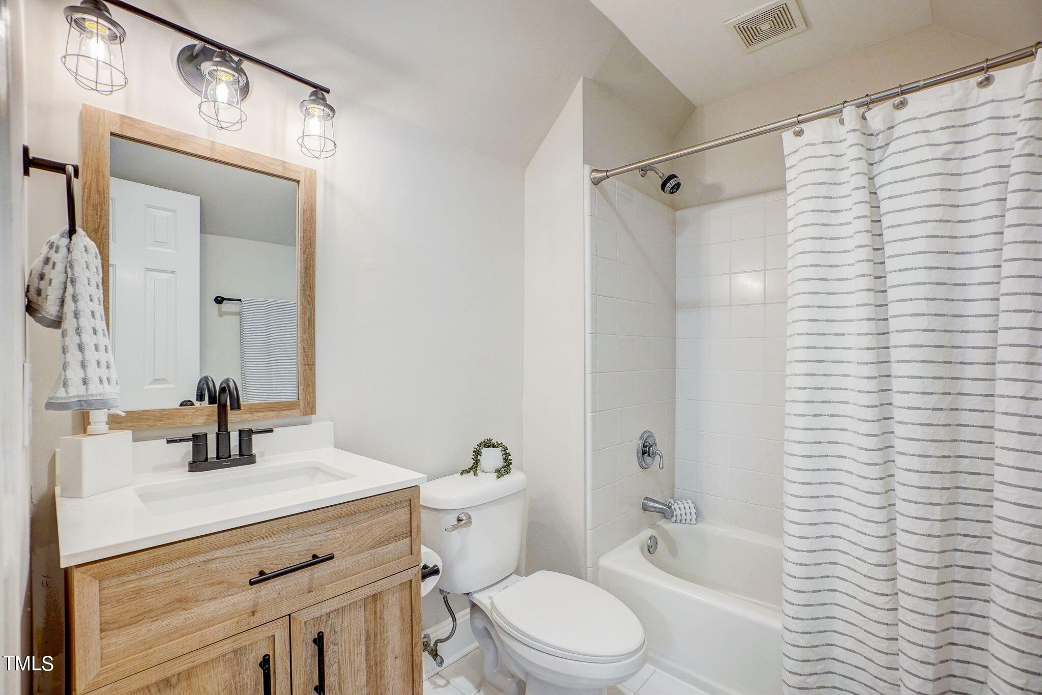5101 Roseland Court Raleigh, NC 27613 - Photo 46 of 71 a bathroom with a sink a toilet a mirror a vanity and shower