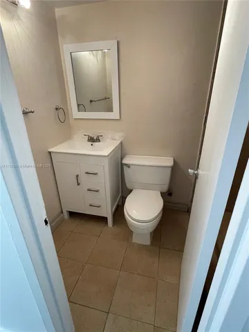 a bathroom with a toilet a sink a vanity and mirror