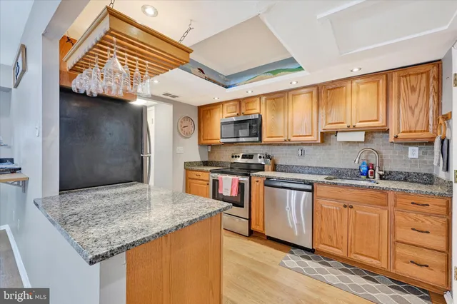a kitchen with stainless steel appliances granite countertop a stove sink and cabinets