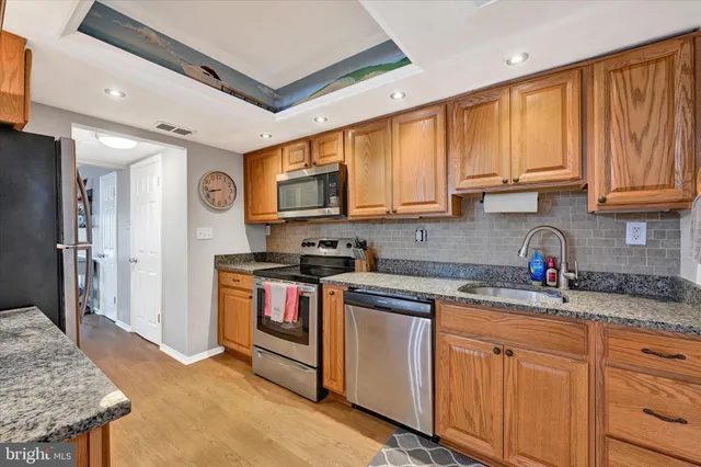 a kitchen with stainless steel appliances granite countertop a stove a sink dishwasher and a refrigerator