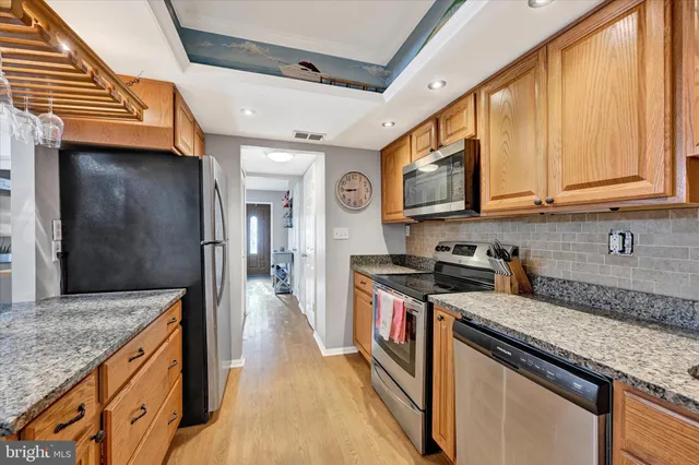 a kitchen with stainless steel appliances granite countertop a stove a sink and a microwave