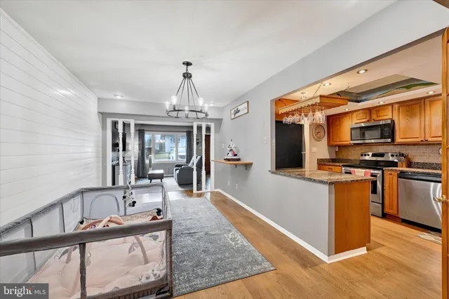 a large kitchen with stainless steel appliances granite countertop a stove and a wooden floors