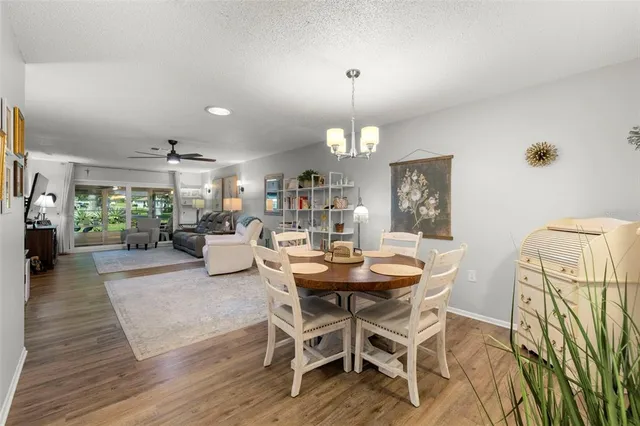 a view of a dining room with furniture a chandelier and wooden floor