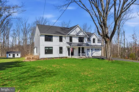 a view of a house with a big yard and large trees