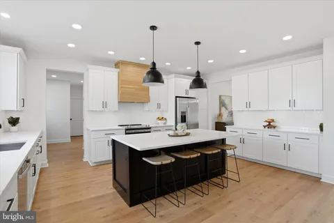 a kitchen with stainless steel appliances granite countertop a sink a stove a refrigerator and a island