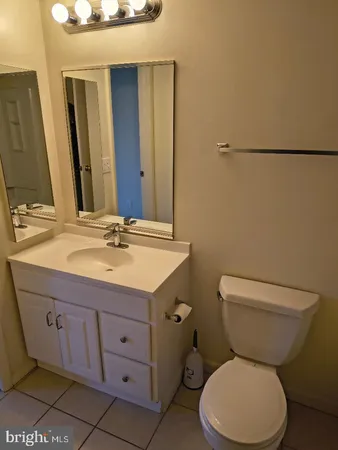 a bathroom with a granite countertop toilet sink and mirror