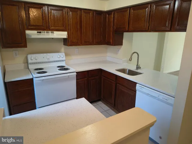 a kitchen with a sink a stove and cabinets
