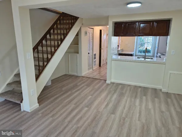 a view of entryway and kitchen with wooden floor