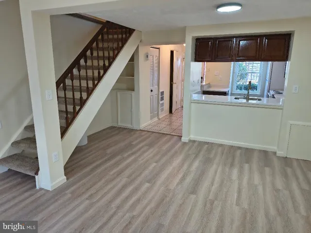 a view of entryway and kitchen with wooden floor