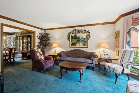 a living room with furniture and a painting on the wall