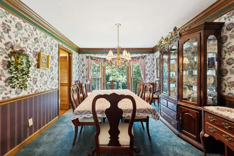 a dining room with furniture a chandelier and wooden floor