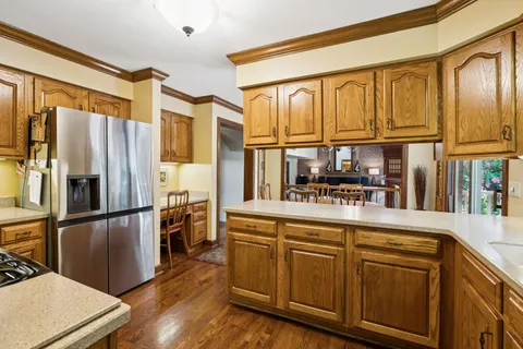 a kitchen with stainless steel appliances granite countertop a refrigerator and a stove top oven