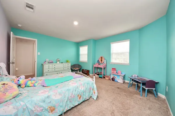 a bedroom with a bed a dresser and a window